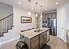 Side view of kitchen showing off the beautiful counter tops and stainless-steel appliances. 