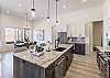 Side view of kitchen showing off the beautiful counter tops and stainless-steel appliances. 