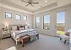 The main bedroom is furnished with a plush King bed, private TV, and walk-in closet. 