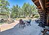 Spacious outdoor patio with comfortable seating, shaded pergola, and scenic views overlooking a serene pool and lush trees
