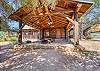 Charming log cabin with a spacious covered porch, rustic wooden beams, and inviting outdoor seating surrounded by nature