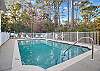 A large, outdoor pool is offered in this complex. Seating is provided for convenience.