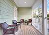 The spacious balcony/porch offers a great space for enjoying outdoors. Seating is provided for convenience.