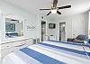 Serene Primary Suite: King-size bed, dresser and generous wardrobe space to stow your belongings neatly away. A private bathroom and mounted television are also provided.