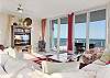 The cozy, yet spacious living area features a sectional sofa, side chair, and television for relaxing and unwinding after a long day in the sun.