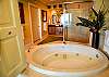 The private bathroom offers a glass shower, and a jetted soaking tub.