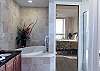 The private bathroom features a jacuzzi tub, shower, double vanity, a private water closet, and is fully stocked with linens for your stay.