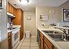 The kitchen offers electric appliances, which include a dishwasher, stove with smooth cooktop, a refrigerator, and also a microwave.