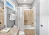 The private bathroom features a tiled tub, shower combo and is fully stocked with linens for your stay.