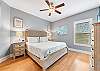 The primary bedroom offers King bedding, bedside tables with lamps, a large chest of drawers and a private bathroom.