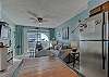 The kitchen offers a stainless refrigerator and a table with seating for 4
