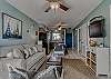 The living area offers a sofa sleeper, 2 side chairs, end tables with lamps and a mounted flat screen television