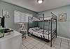 Bedroom 2 offers a full over full bunk bed, a side table with lamp, a dresser for storing your personal belongings and a flat screen television