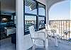 A private balcony is accessed from the living area and overlooks the pool