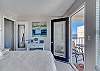 The bedroom offers private balcony access with seating 