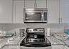 The kitchen offers a stainless stove with a smooth  electric cooktop and a built in microwave