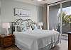The inviting primary bedroom features king bedding and access to the spacious balcony.