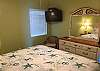 Bedroom 2 offers King bedding, mirrored dresser and a mounted television