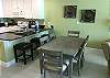 The dining area offers a table with seating for 6. Three additional seats are provided at the adjacent bar