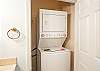 The guest bathroom features a stack washer/dryer for convenience.