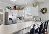 The kitchen features a large bar which is perfect for serving meals and seating additional guests for mealtime.