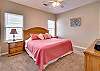 Bedroom 3 offers king bedding, and bedside tables. A private bathroom is featured for convenience.