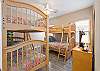 This guest room features a full over twin bunk as well as a twin over twin bunk. This is the perfect space for kids to have a vacation they can call their own. A private bathroom is featured in this space for convenience.