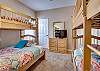 This bedroom offers 2 sets of bunk beds which will accommodate 5 total. A small dresser is provided that holds a television.