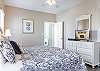 The spacious primary bedroom is fully furnished to make you feel right at home. A television is featured to help you unwind at night after a long day of fun in the sun.