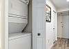 A laundry closet featuring a stack washer/dryer is conveniently located in the kitchen for use during your stay.