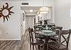 Open dining area features a table with seating for 4, with 2 additional seats offered at the adjacent bar.