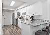 The fully stocked kitchen boasts gleaming stainless appliances, stylish granite counters, and endless possibilities for culinary creativity.