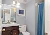 The private, guest bathroom features a single vanity, tub/shower combo and is fully stocked with linens for your stay.