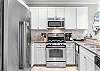The fully stocked kitchen features stainless appliances which include a dishwasher, beverage cooler, ice maker, gas range, built in microwave, and large side by side refrigerator freezer. Fully stocked cabinetry that offers all things needed for preparing meals during your stay.