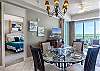 The spacious, open dining area features a table with seating for 4, with additional seats offered at the adjacent bar.