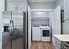 The spacious kitchen features a laundry closet with a full size washer and dryer for convenience.