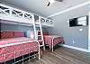 Guest bedroom 2 offers sturdy built in bunks with queen beds underneath. A mounted television is provided for enjoying in your down time.