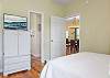 Bedroom 2 features a television, an armoire for personal storage, and private access to the guest bathroom for convenience.