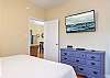 The primary bedroom features a dresser for storing your personal belongings, and is also equipped with a mounted television to help you unwind at night.