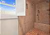The upstairs, private bathroom offers a large tiled shower.