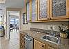 A wet bar is provided which features an ice maker and beverage sink. 