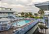 The complex pool features loungers and chairs for spending a relaxing day by the pool.