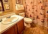 Bedroom 1 offers a private bathroom that features a tub/shower combo, a vanity, and is fully stocked with linens