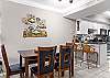 The open dining area features a table with seating and additional seats are offered at the adjacent bar. 