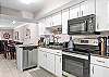 The spacious kitchen features black and stainless appliances and is fully stocked with all items needed for preparing meals during your stay.