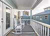 The spacious balcony features plenty of seating including rocking chairs to make the porch sitting most enjoyable.