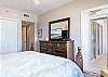 The spacious primary bedroom features private balcony access and a television for enjoying in your down time.