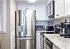 Elevate your culinary experience in a fully stocked kitchen featuring stainless appliances, generous cabinet space, and sleek countertops—ideal for preparing meals.