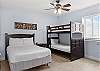 This guest bedroom features a full size bed as well as a set of twin over twin bunk beds. A private bathroom is also provided for convenience.