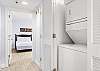 A laundry closet is featured in the hallway and offers a stack washer/dryer for convenience.